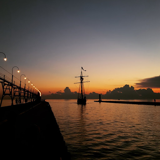 The Tall Ship Friends Good Will coming into port at sunset in South Haven, Michigan